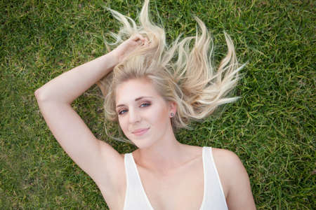 Smiling woman laying in grassの写真素材