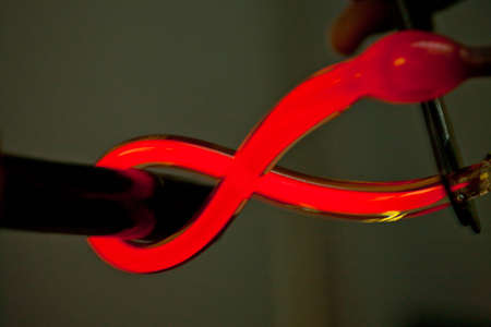 Close up of red hot glass being bent in glass factoryの写真素材