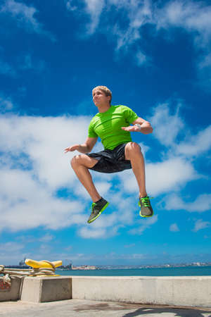 Young man jumping while fitness trainingの写真素材
