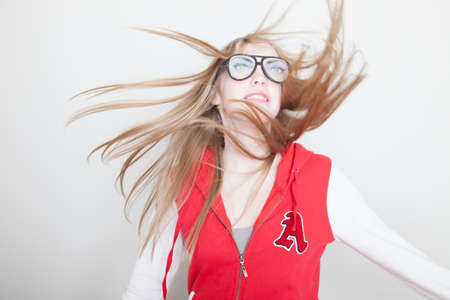 Girl wearing fake glasses swinging hairの写真素材