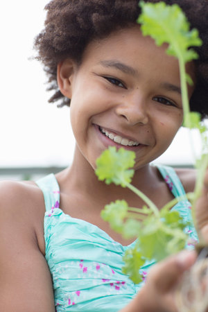 Portrait of girl holding plant