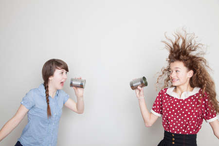 Girls using tin can telephones