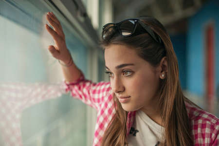 Teenage girl looking through window