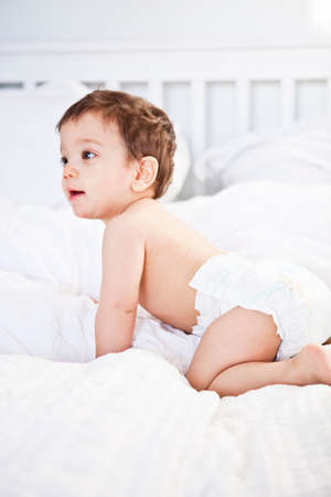 Baby boy crawling on bedの写真素材