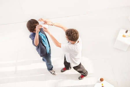 Teenage boys fighting over postcardの写真素材