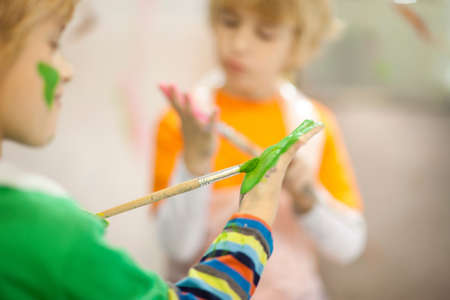 Boys painting their handsの写真素材