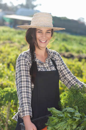 Young woman with vegetables grown at farmの写真素材
