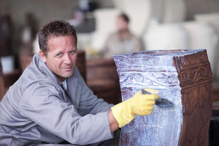 Painting and staining process in pottery factoryの写真素材