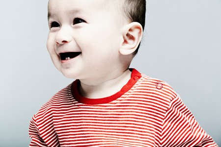 Portrait of baby boy wearing striped top looking awayの写真素材