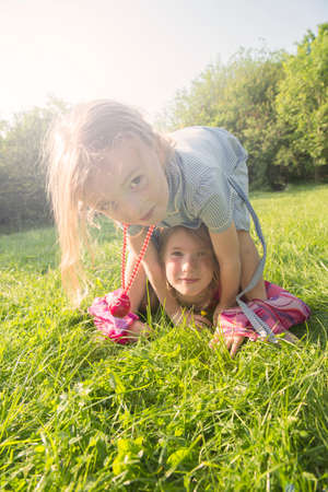 Portrait of sisters playing in field in summerの写真素材