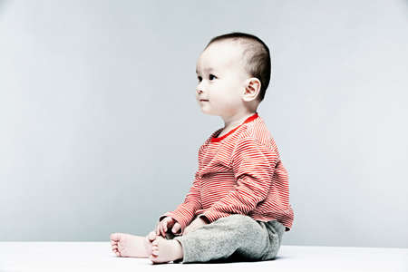 Portrait of baby boy wearing striped top looking awayの写真素材