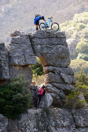 Mountain biking couple on rock formationの写真素材