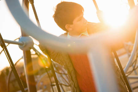 Boy on rope swing in playgroundの写真素材