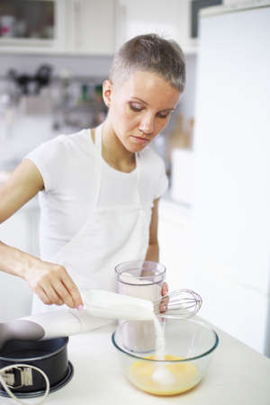 Woman pouring sugar into mixing bowl