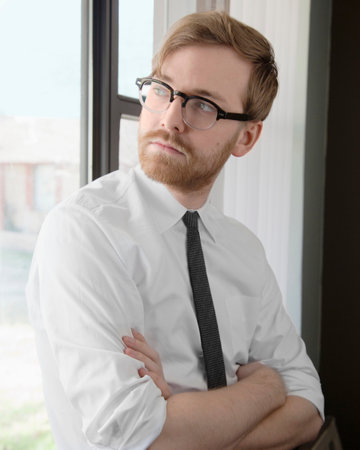 Young man wearing spectacles and tie looking awayの写真素材