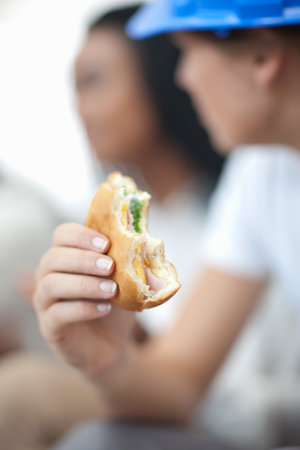 Female worker holding sandwichの写真素材