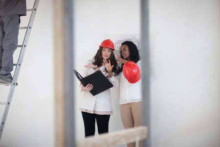 Architect and designer discussing plans on construction siteの写真素材