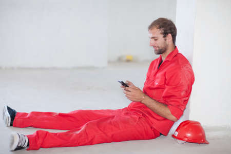 Construction worker sitting on floor taking a breakの写真素材