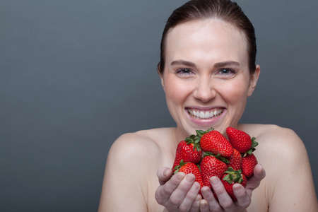Young woman holding strawberriesの写真素材