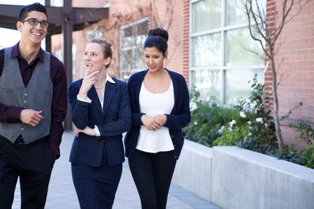Three young businesspeople outside office exteriorの写真素材