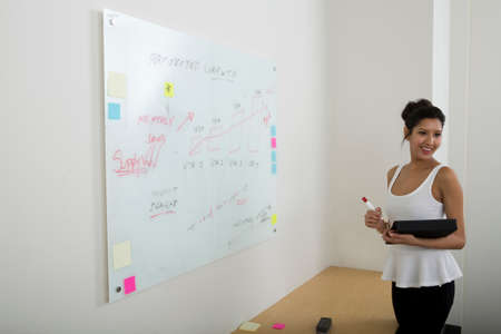 Young woman using whiteboardの写真素材