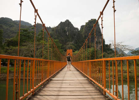 Man on bridge over river, Vang Vieng, Laos