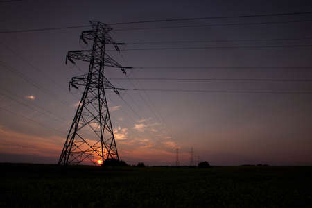 Silhouette of electrical towers at sunset