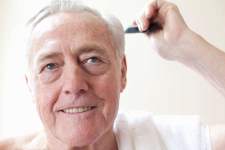 Senior man combing hairの写真素材