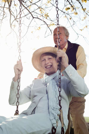 Husband pushing wife on swingの写真素材