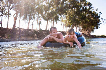 Man and boy floating on inflatable ring