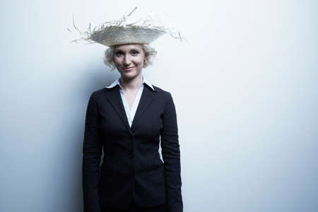 Studio portrait of blond businesswoman wearing straw hatの写真素材