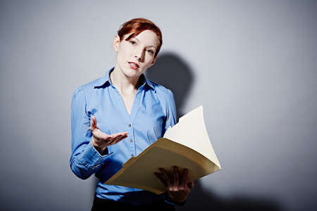 Studio portrait of young woman holding folderの写真素材