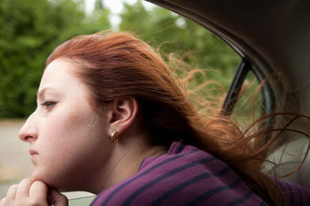 Girl looking out of car windowの写真素材