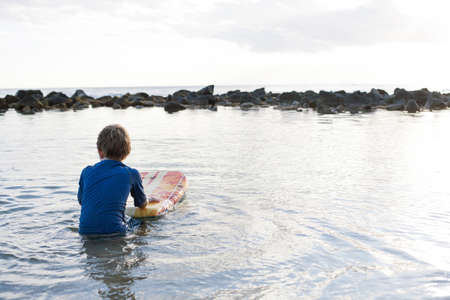 Young boy in sea with bodyboard, Kauai, Hawaii, USAの写真素材