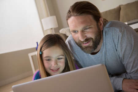 Father and daughter looking at laptopの写真素材