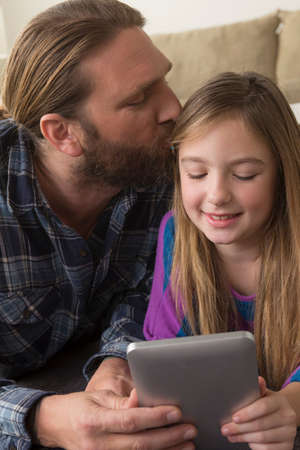 Girl looking at digital tablet with fatherの写真素材