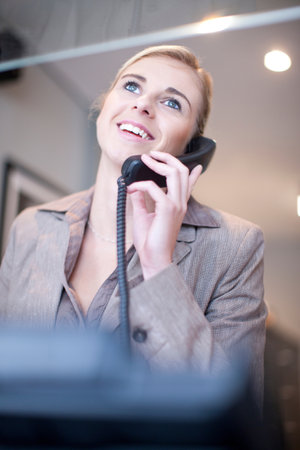 Receptionist talking on telephoneの写真素材
