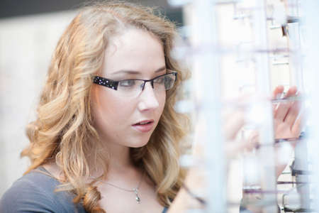 Young woman looking at eyeglasses display
