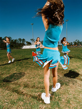 Cheerleaders performing dance routine on sports fieldの写真素材