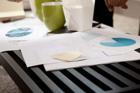 Paperwork of graphs and charts on coffee tableの写真素材