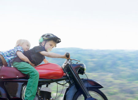 Brothers riding motorcycleの写真素材