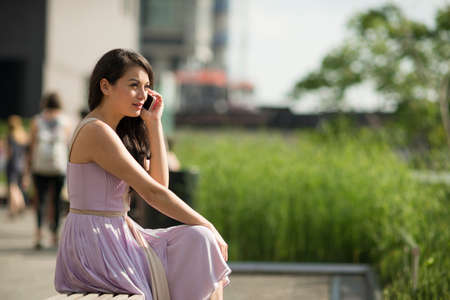 Mid adult women using mobile phone in High Line Park, New York City