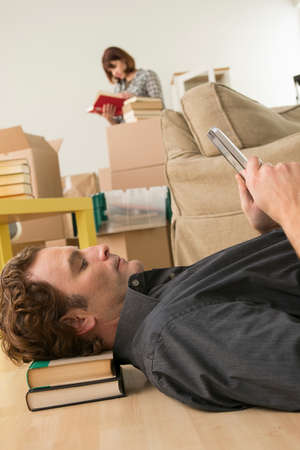 Man lying on floor looking at digital tablet whilst movingの写真素材