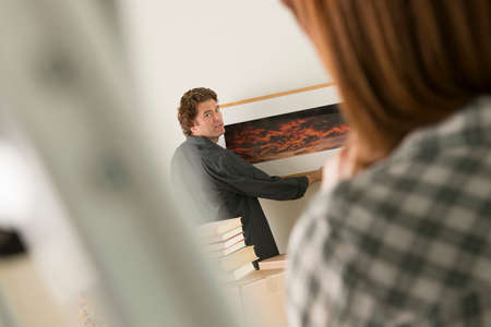 Couple hanging picture frame in new homeの写真素材