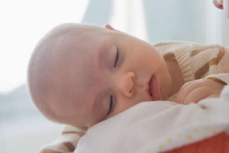 Baby boy sleeping on mother's shoulder, close upの写真素材
