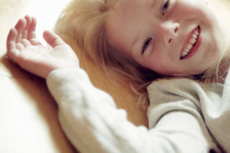 Young girl lying on back, smiling