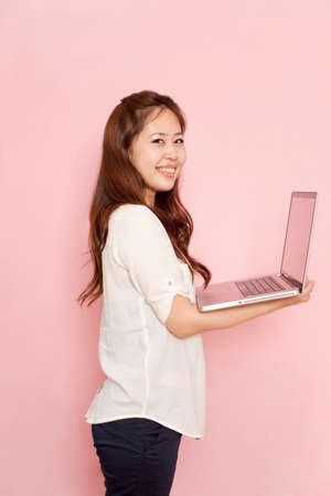 Young woman holding laptop, portraitの写真素材