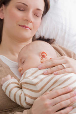 Mid adult mother resting with baby boy