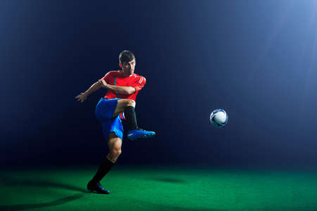 Young male soccer player kicking ballの写真素材
