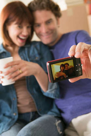 Couple taking self portrait whilst moving house
